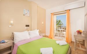 a bedroom with a green bed with a view of the ocean at Panorama-Seaview Studios & Apartments in Hersonissos