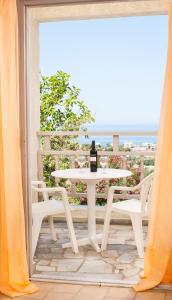 a table and chairs on a balcony with a view of the ocean at Panorama-Seaview Studios & Apartments in Hersonissos