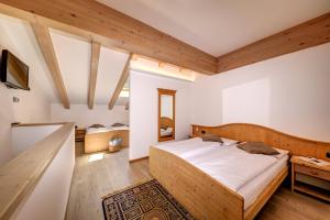 sypialnia z dużym łóżkiem w pokoju z drewnianym sufitem w obiekcie Aparthotel Wellness Villa di Bosco w mieście Tesero