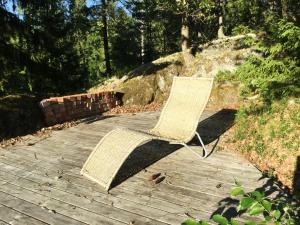 a rattan chair sitting on a wooden boardwalk at Lillstuga Strömma in Värmdö