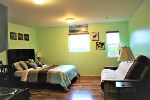 a bedroom with green walls and a bed and a chair at Grace and Bill's Freedom Hills B&B in Talkeetna