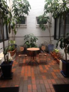 雪梨的住宿－沙威雙灣酒店，天井配有桌椅和盆栽植物