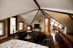 um quarto com uma cama e cadeiras num sótão em Hatfield House on Hibernia em Stratford