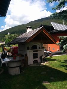 a building with a pizza oven in a yard at Gästehaus Maria in Steinach am Brenner