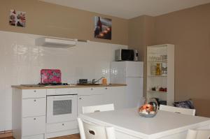 a kitchen with a white refrigerator and a white table at Au Songe du Valier- Chalets in Seix