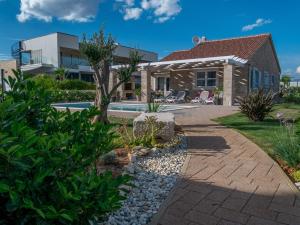 a house with a garden and a swimming pool at Villa Stina in Sukošan