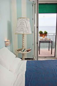 een slaapkamer met een bed en een lamp en een balkon bij B&B Fronte Del Mare in Salerno