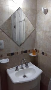 a bathroom with a sink and a mirror at San Clemente Aventura in San Clemente del Tuyú +77 photos