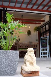 una estatua frente a un edificio con plantas en Yen Aura Boutique Hotel, en Chiang Mai
