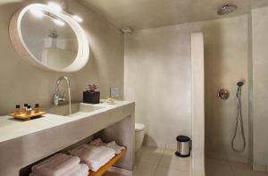 a bathroom with a sink and a toilet and a mirror at Mirto's Studios in Fira