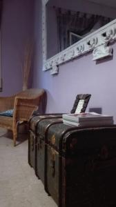 ローマにあるCinema Apartmentのスーツケース、鏡、椅子が備わる客室です。