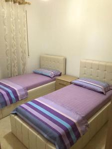dos camas sentadas una al lado de la otra en una habitación en Radhima Beach Apartment-Tirana Resort, en Orikum