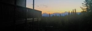 a silhouette of a building with the sunset in the background at Grace and Bill's Freedom Hills B&B in Talkeetna