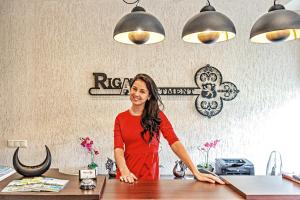 a woman standing at a counter in a restaurant at RIGAAPARTMENT SONADA Aparthotel - Private Parking & High Speed WIFI in Riga