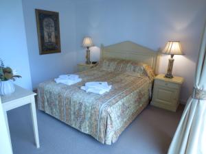 ein Schlafzimmer mit einem Bett mit zwei Tischen und zwei Lampen in der Unterkunft Lights Landing Apartments in Adelaide