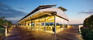 a building with a deck with tables and chairs at Hotel Ristorante I Castelli in Alba