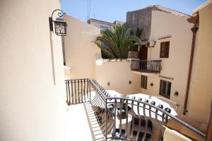 a balcony of a building with stairs and a plant at Italiana Resort Maniace in Siracusa