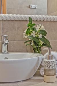 a bathroom with a sink and a vase of flowers at Alisachni Villas in Lefkos Karpathou