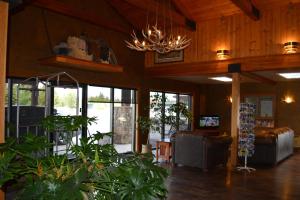 a living room with a chandelier and some plants at Brandin' Iron Inn in West Yellowstone