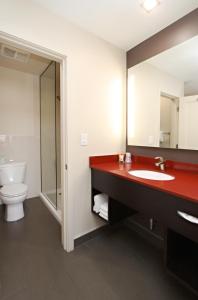 uma casa de banho com um lavatório vermelho e um WC. em Best Western Plus Dragon Gate Inn em Los Angeles