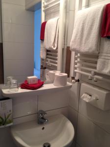 a bathroom with a sink and a toilet and towels at Hotel Royal in Villingen-Schwenningen