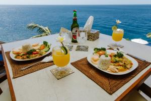 a table with two plates of food and drinks at Villa Infinite Horizon in Amed