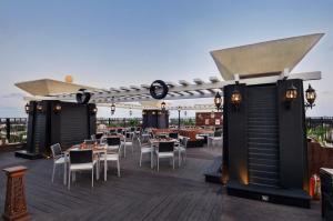 a restaurant with tables and chairs on a deck at Pride Hotel, Chennai in Chennai