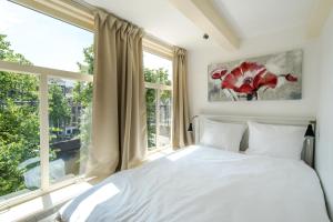 a bedroom with a bed and a large window at The Blue Stairs in Amsterdam