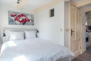 - une chambre blanche avec un lit blanc et une cuisine dans l'établissement The Blue Stairs, à Amsterdam