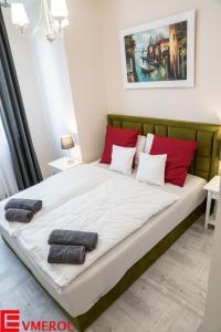 uma cama grande num quarto com almofadas vermelhas em Evmerol Apartment (Hallera) em Breslávia
