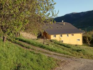 a yellow house on a hill with a dirt road at Les logis de Lucie in Selonnet