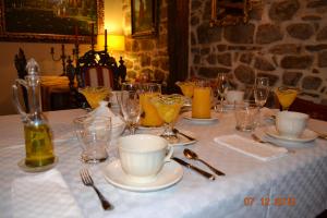 Palacio de Trasvilla في Escobedo: طاولة عليها مفرش وطاولة بيضاء وكاسات