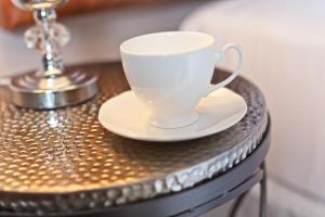 a white coffee cup sitting on top of a table at The Glen Guest House in Kendal