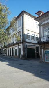 a large white building with a garage on a street at casa cardeal saraiva in Ponte de Lima