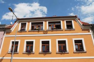 プルゼニにあるApartments & Suites Žlutá Hruškaの窓と花箱のあるオレンジ色の建物