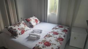 Un dormitorio con una cama con mantas y almohadas rojas y blancas en Flat Visual do Porto, en Fernando de Noronha