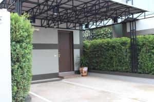 a entrance to a building with a door and plants at Sweety Resort in Bangna