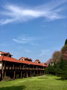 橫山鄉的住宿－萬瑞渡假村，绿色田野上一座红色屋顶的建筑