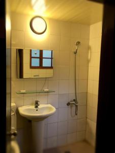 a bathroom with a sink and a shower with a mirror at Wan Ruey Resort in Hengshan