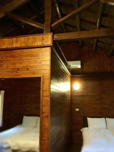 two beds in a room with wooden walls at Wan Ruey Resort in Hengshan