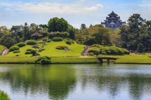 岡山市にあるダイワロイネットホテル岡山駅前の湖を背景に建つ公園