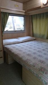 Cama en habitación pequeña con ventana en Villaggio Camping Calapineta en Siniscola