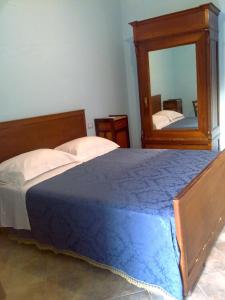 1 dormitorio con cama y espejo grande en Agriturismo le Cammarose, en Felitto