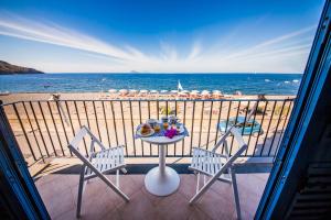 a table and chairs on a balcony with a view of the beach at Mistral Residence in Canneto