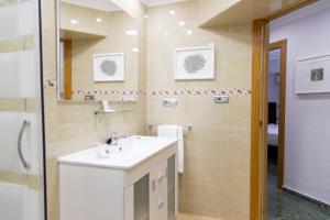a bathroom with a sink and a mirror at Vila Barbera Apartment Center in Valencia