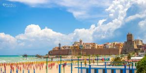 een strand met een groep vlaggen op het zand bij Le Stanze del Centro in Termoli