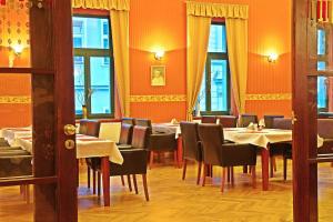 Zlatý Lev Žatec في زاتيك: مطعم به طاولات وكراسي وجدران برتقالية