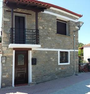 uma casa de pedra com uma porta e uma varanda em Old Alleys em Agios Nikolaos