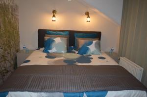 1 dormitorio con 1 cama grande con almohadas azules y blancas en B&B Bij MoeMee en Gante
