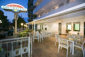 a restaurant with white chairs and tables and a sign at Albergo Arcobaleno in Sottomarina